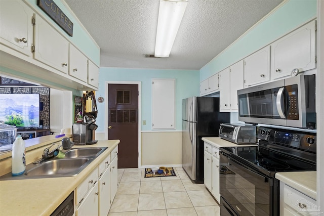 kitchen featuring light tile patterned floors, sink, stainless steel appliances, a textured ceiling, and white cabinets