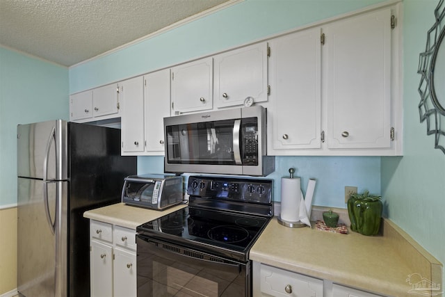 kitchen featuring appliances with stainless steel finishes, white cabinets, and a textured ceiling