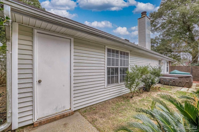 property entrance with a hot tub
