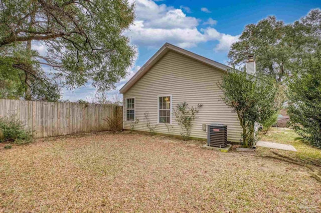 view of home's exterior featuring central AC unit and a lawn