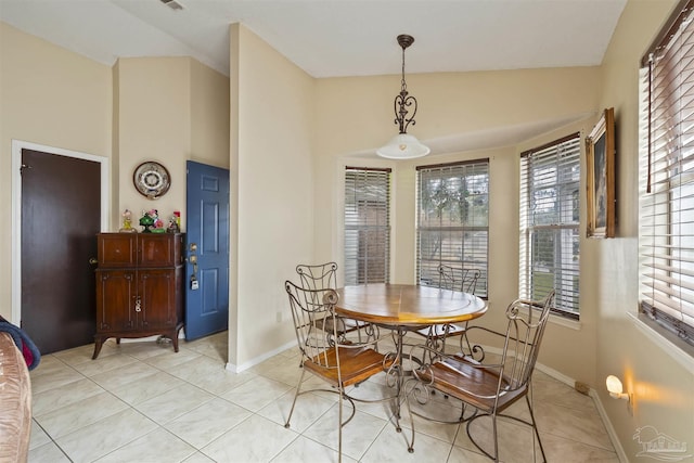 tiled dining space with lofted ceiling