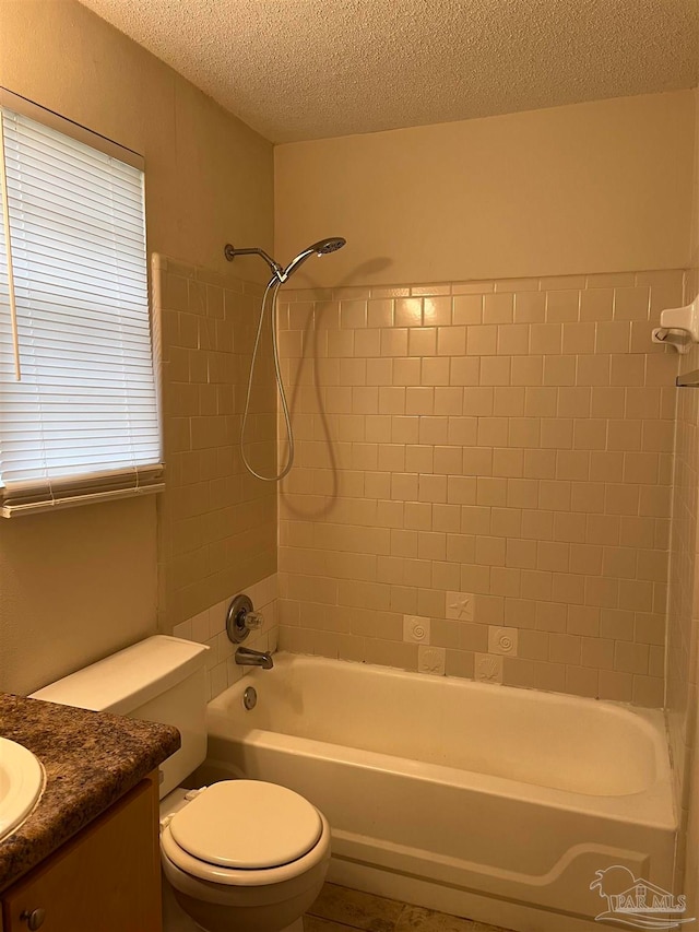 full bathroom featuring vanity, a textured ceiling, toilet, and tiled shower / bath combo