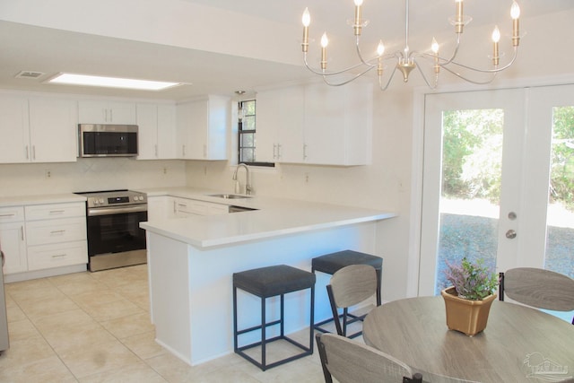 kitchen featuring pendant lighting, white cabinetry, and stainless steel appliances