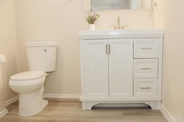 bathroom featuring wood-type flooring, vanity, and toilet