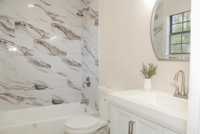 full bathroom featuring vanity, tiled shower / bath combo, and toilet