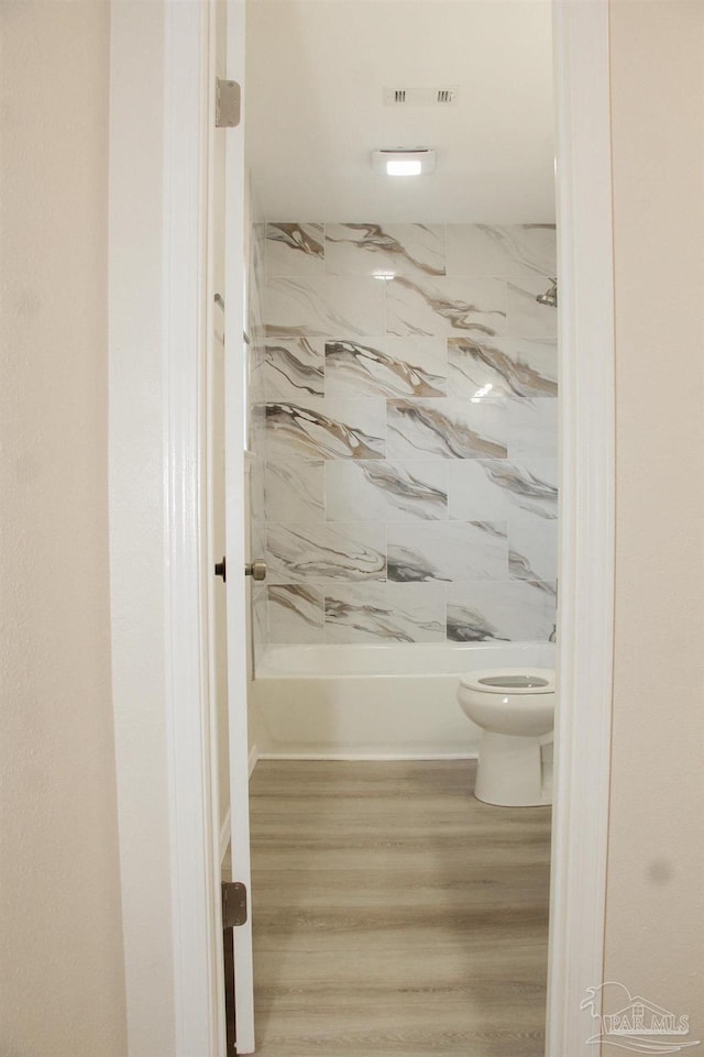 bathroom with hardwood / wood-style flooring and toilet