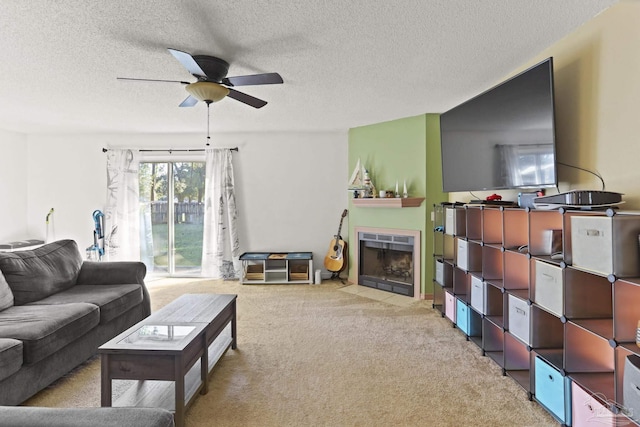 living room with ceiling fan, light colored carpet, and a textured ceiling