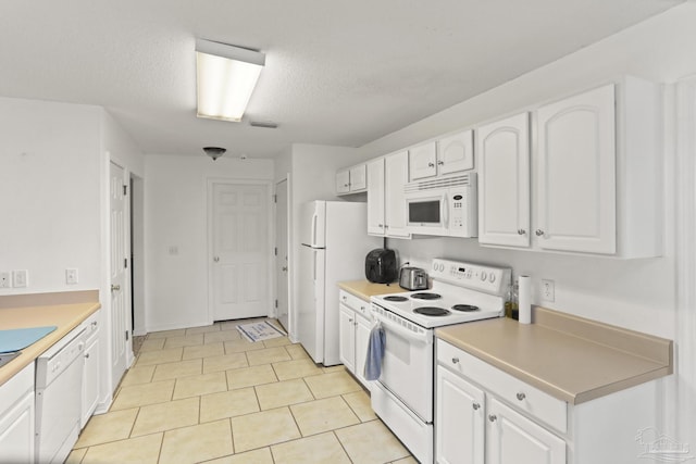 kitchen featuring white cabinetry, light tile patterned flooring, white appliances, and a textured ceiling