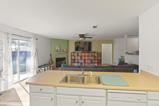 kitchen with white dishwasher, ceiling fan, sink, white cabinetry, and light tile patterned flooring