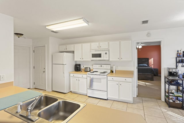 kitchen with sink, white cabinets, white appliances, and light tile patterned floors