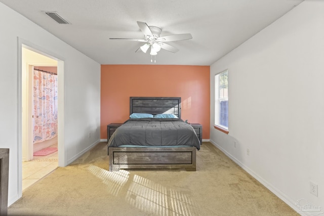 carpeted bedroom featuring ensuite bathroom and ceiling fan