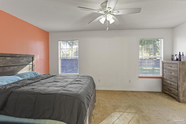 carpeted bedroom with ceiling fan and a textured ceiling