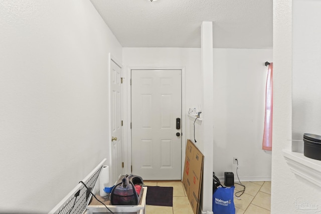 doorway to outside with light tile patterned floors and a textured ceiling