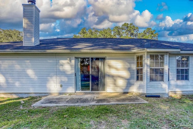 back of house featuring a lawn and a patio area