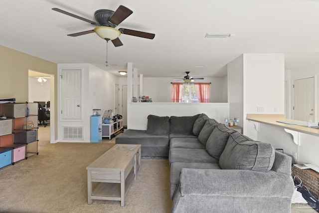 carpeted living room featuring ceiling fan