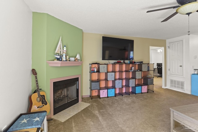 interior space with ceiling fan, carpet, and a textured ceiling