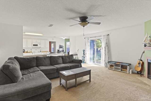 carpeted living room with ceiling fan and a textured ceiling