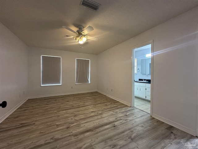 4885 Mayo Cir, Pace, FL 32571 - unfurnished room featuring wood finished floors, a ceiling fan, baseboards, a sink, and a textured ceiling