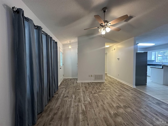 4885 Mayo Cir, Pace, FL 32571 - empty room with a textured ceiling, dark wood-style flooring, ceiling fan, vaulted ceiling, and baseboards