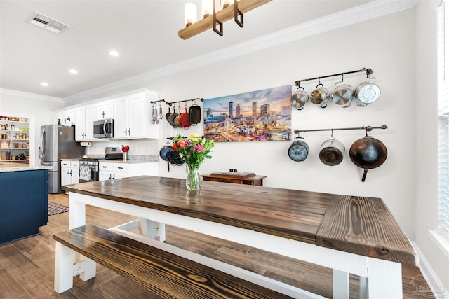 dining area with dark hardwood / wood-style floors and ornamental molding