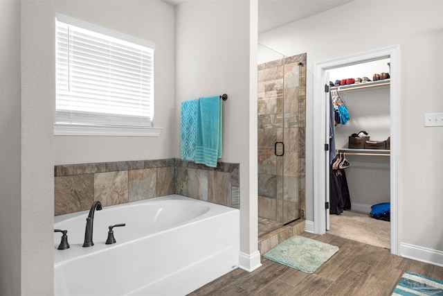 bathroom featuring hardwood / wood-style floors and plus walk in shower