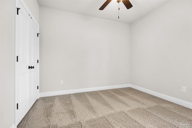 carpeted spare room with ceiling fan