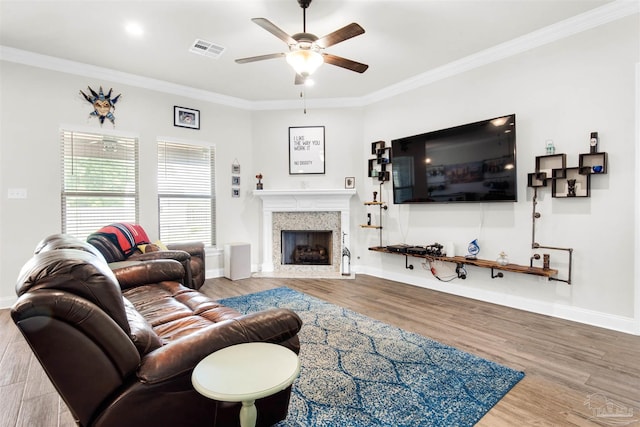 living room with hardwood / wood-style flooring, ceiling fan, and ornamental molding