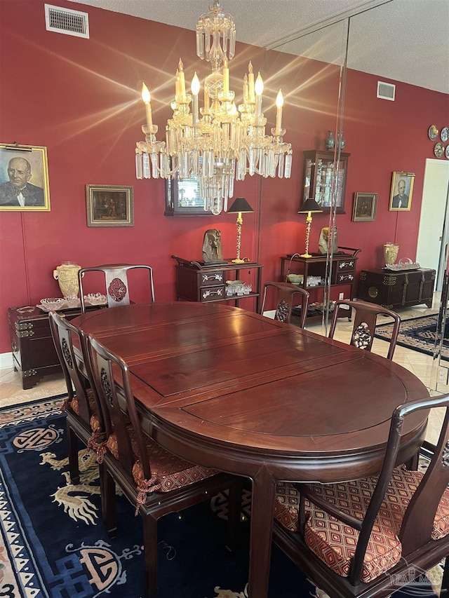 tiled dining space featuring a notable chandelier and a textured ceiling