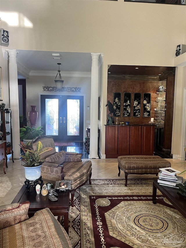 living room with decorative columns, ornamental molding, and french doors