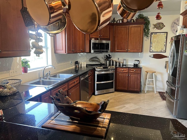 kitchen with tasteful backsplash, sink, light tile patterned floors, and stainless steel appliances