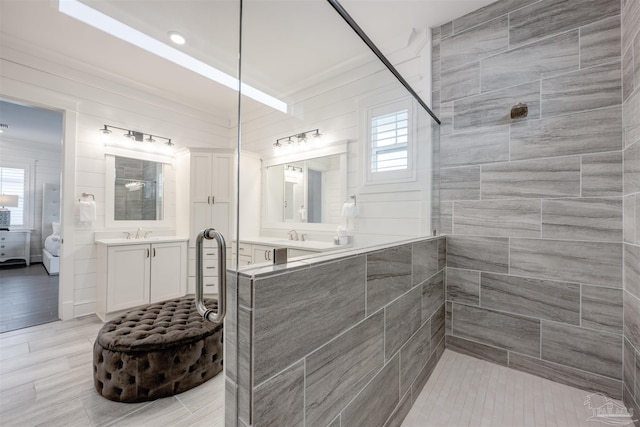 bathroom featuring tiled shower, plenty of natural light, and vanity