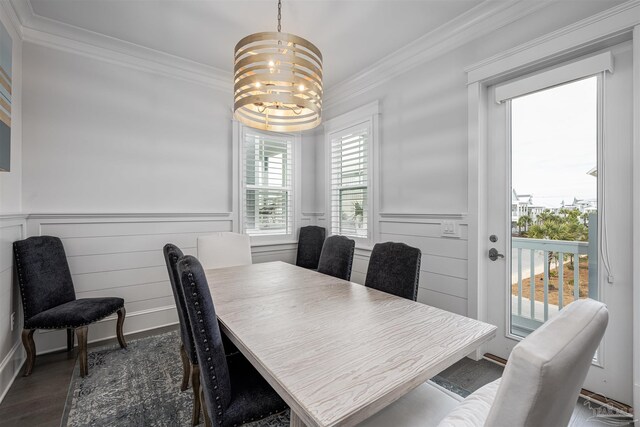 dining area featuring dark wood-type flooring, crown molding, and an inviting chandelier