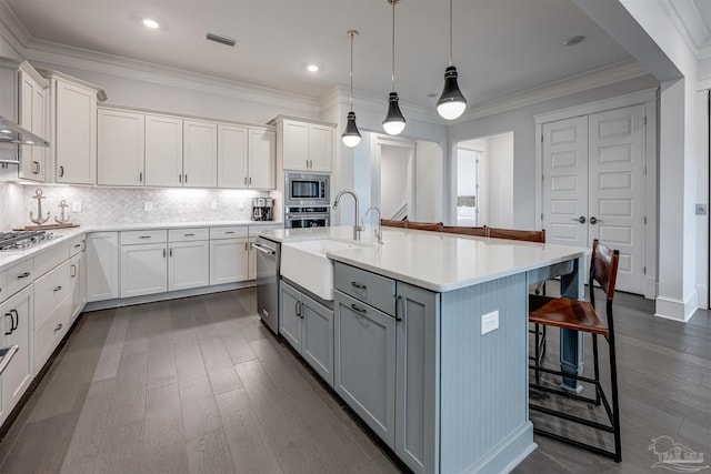 kitchen featuring appliances with stainless steel finishes, white cabinetry, and a kitchen island with sink