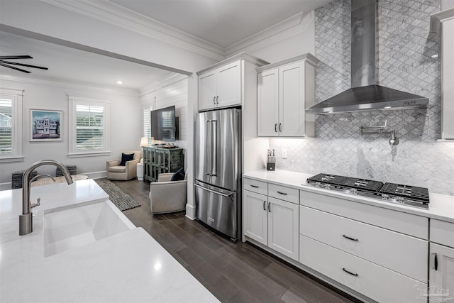 kitchen with sink, white cabinetry, stainless steel appliances, and wall chimney exhaust hood