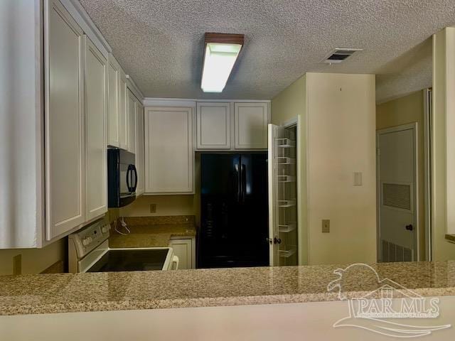 kitchen with white cabinetry, black appliances, a textured ceiling, and light stone counters