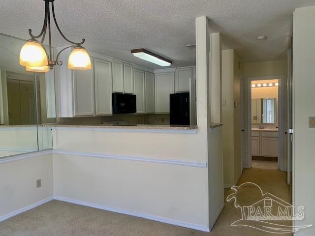 kitchen featuring decorative light fixtures, black appliances, a textured ceiling, and light colored carpet