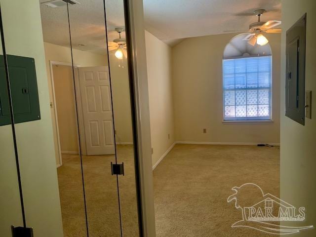 carpeted spare room featuring electric panel and ceiling fan