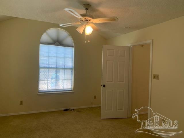 spare room with carpet, a textured ceiling, and ceiling fan