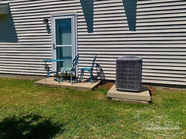 property entrance with a yard and cooling unit