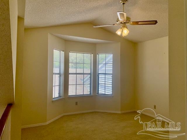 carpeted spare room with ceiling fan and a textured ceiling