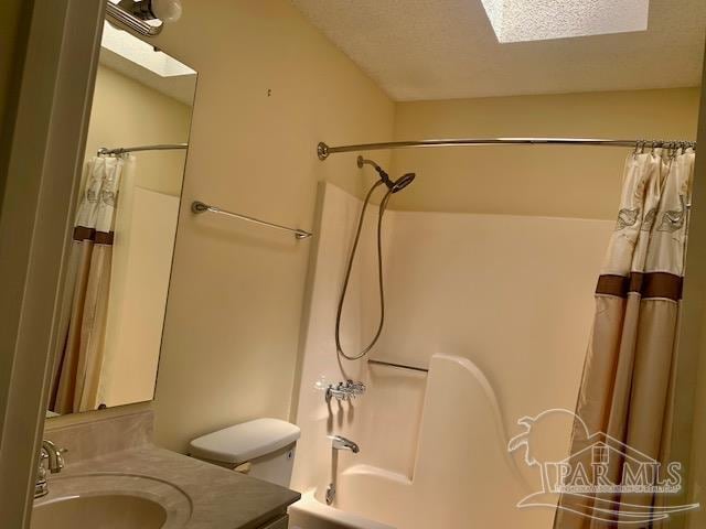 full bathroom with a skylight, toilet, vanity, and shower / tub combo