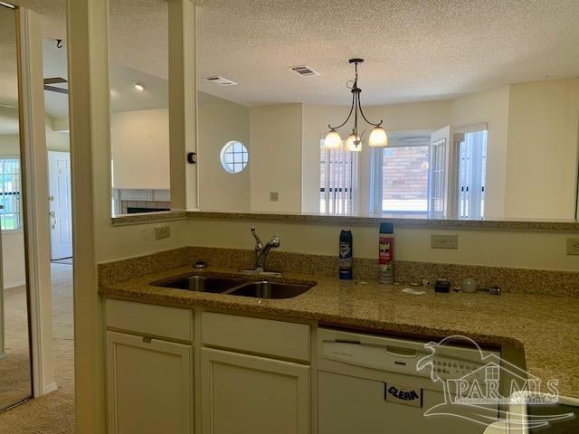 kitchen with sink, a textured ceiling, and stone countertops