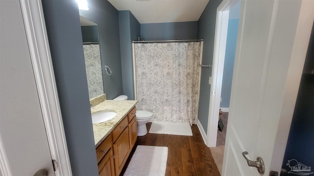 bathroom featuring walk in shower, toilet, vanity, and hardwood / wood-style flooring