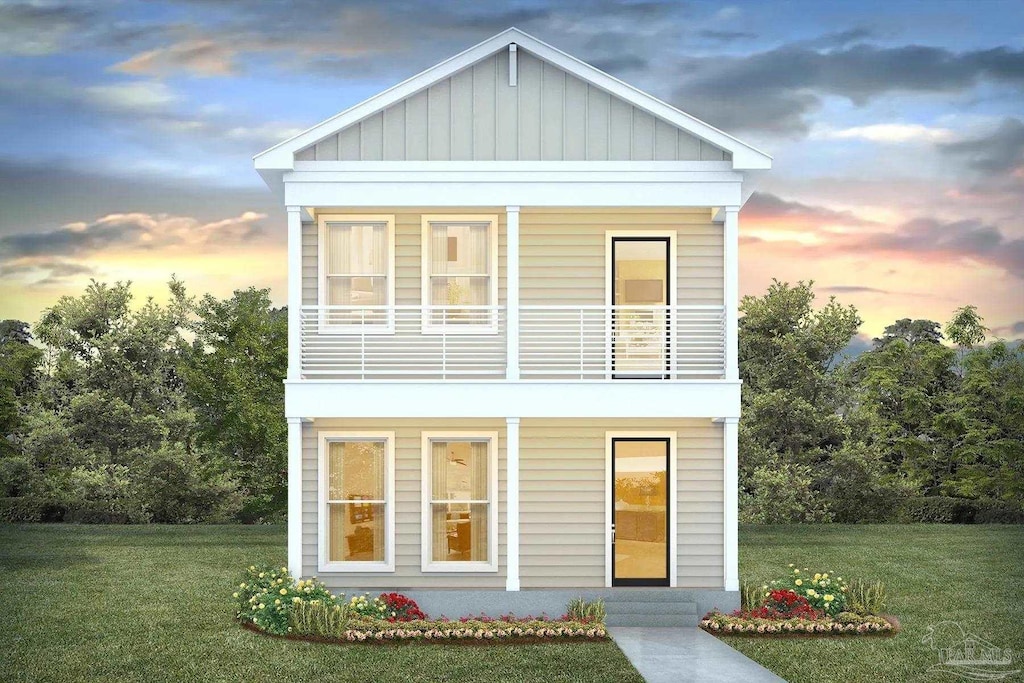 view of front of home with board and batten siding, a front yard, and a balcony