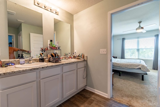 bathroom featuring vanity, a textured ceiling, hardwood / wood-style flooring, and ceiling fan