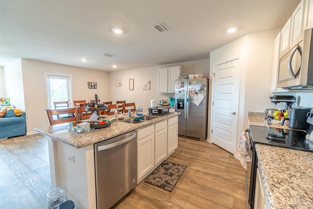 kitchen with a center island, light hardwood / wood-style flooring, stainless steel appliances, white cabinetry, and sink