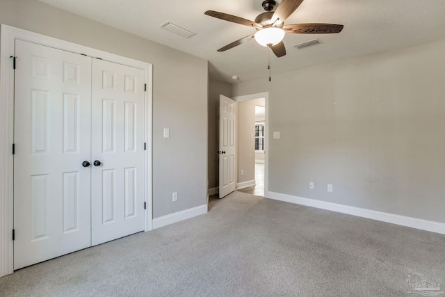 unfurnished bedroom with light carpet, a closet, visible vents, and baseboards