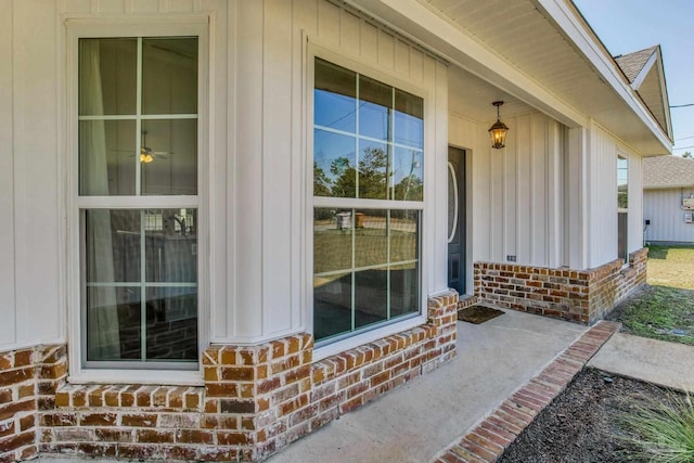 entrance to property featuring brick siding and a shingled roof