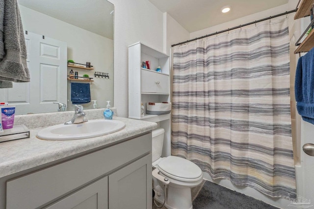 bathroom with toilet, curtained shower, and vanity