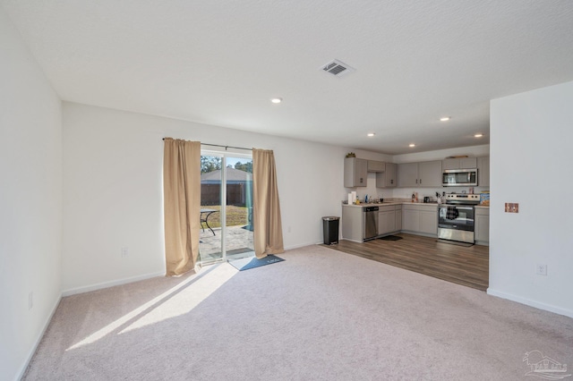 unfurnished living room with recessed lighting, visible vents, dark carpet, and baseboards